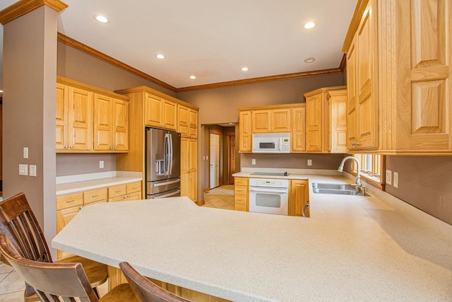 kitchen featuring a breakfast bar area, kitchen peninsula, sink, crown molding, and white appliances