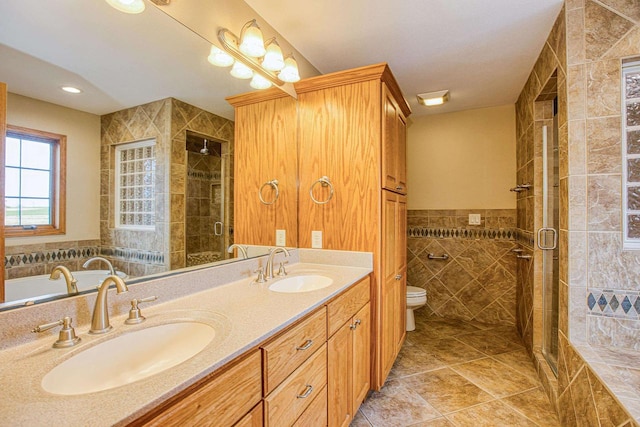 bathroom featuring vanity, walk in shower, toilet, and tile walls