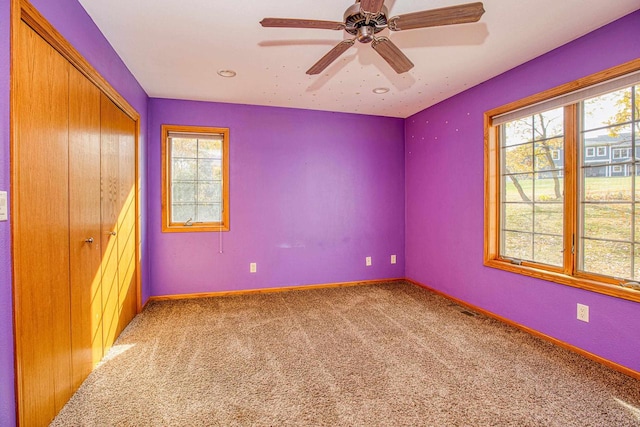 unfurnished bedroom featuring a closet, ceiling fan, and carpet flooring