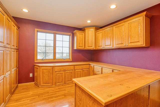 kitchen featuring kitchen peninsula and light wood-type flooring