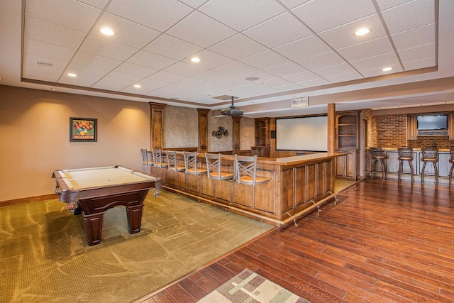 rec room with a paneled ceiling, bar, wood-type flooring, and pool table