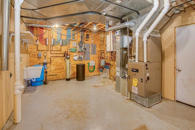 basement featuring sink, heating unit, and a workshop area