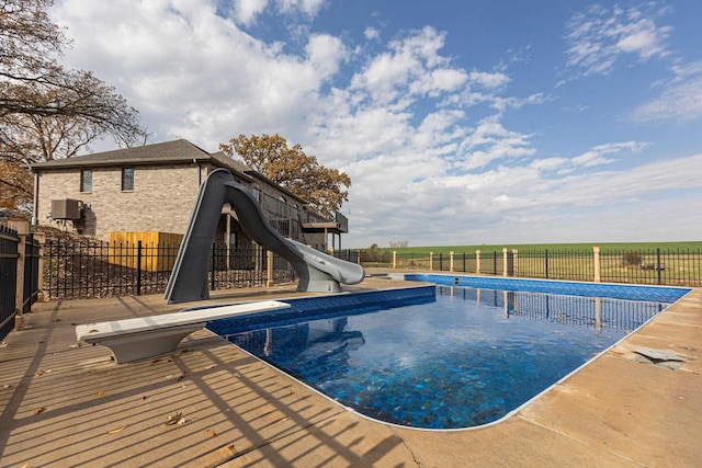 view of pool featuring a water slide and a diving board