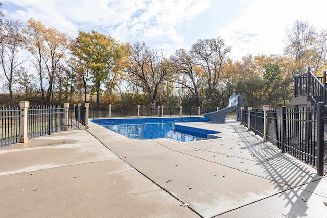 view of swimming pool with a patio area and a water slide