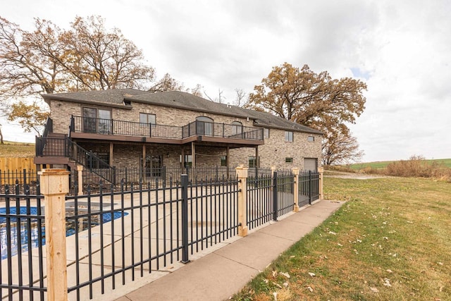 view of gate with a yard and a pool side deck