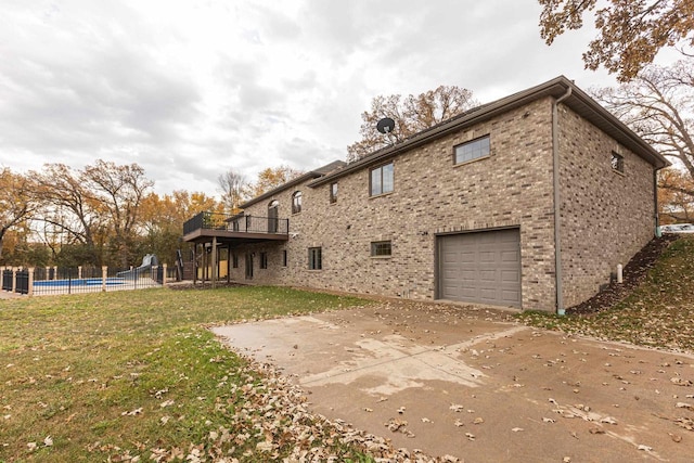 view of property exterior featuring a yard, an empty pool, and a garage