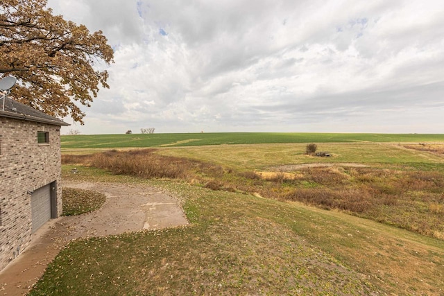 view of yard featuring a rural view and a garage