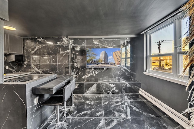 bathroom with decorative backsplash and a baseboard heating unit