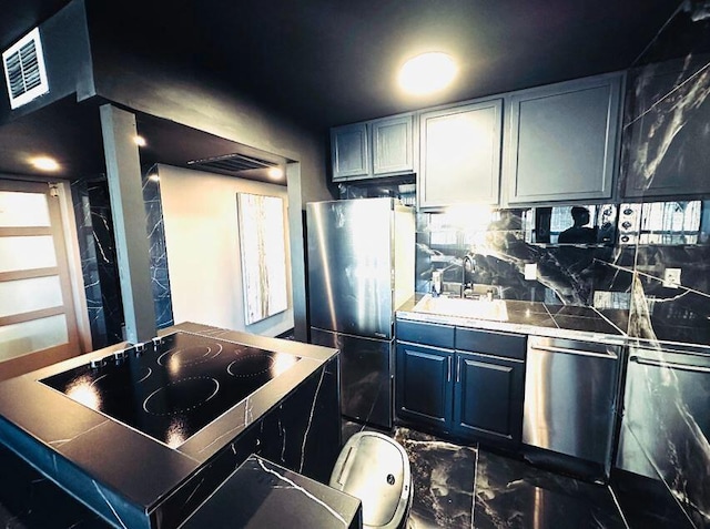 kitchen with sink, stainless steel appliances, and tasteful backsplash