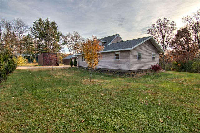 yard at dusk featuring a storage shed