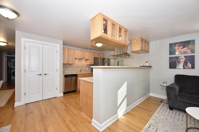 kitchen with kitchen peninsula, stainless steel appliances, light wood-type flooring, and light brown cabinets