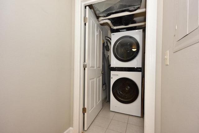 washroom featuring stacked washer and clothes dryer and light tile patterned floors