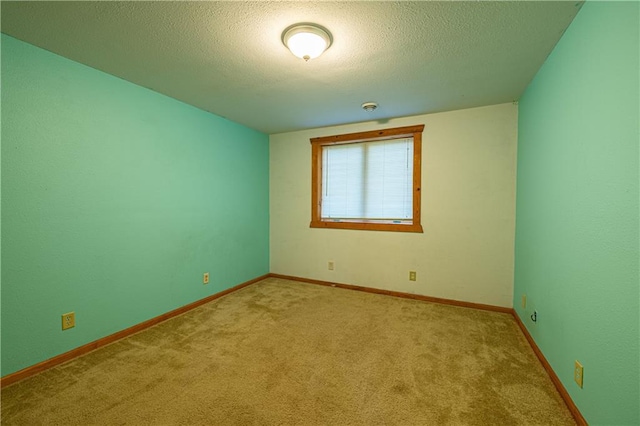 spare room with light carpet and a textured ceiling