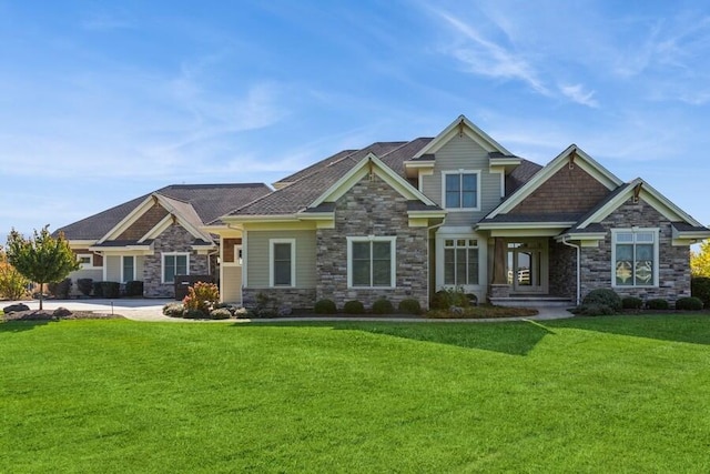 craftsman-style house featuring stone siding and a front lawn