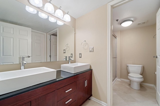 bathroom featuring vanity, a shower with shower door, and toilet