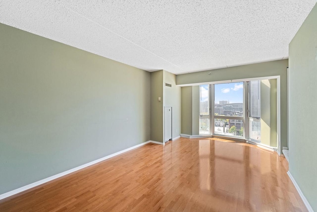 unfurnished room featuring a textured ceiling and light wood-type flooring