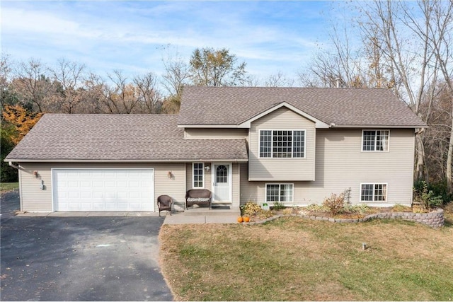 split level home with a garage and a front lawn