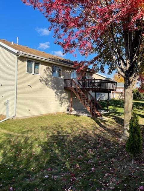 rear view of property featuring a yard and a deck