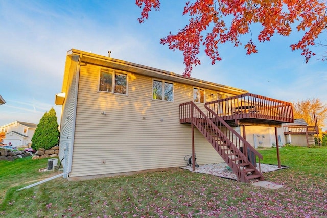 rear view of property featuring a wooden deck, a lawn, and central AC unit