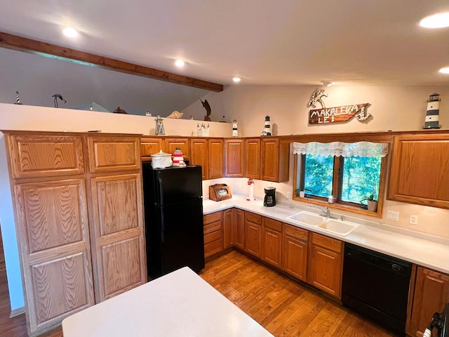 kitchen featuring sink, black appliances, light hardwood / wood-style flooring, and vaulted ceiling with beams