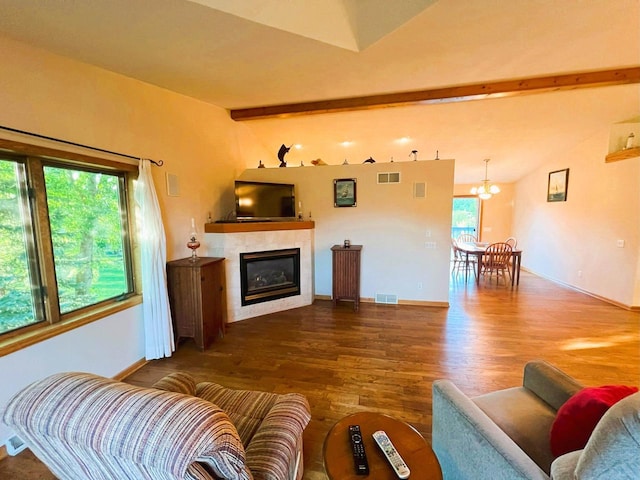 living room with a wealth of natural light, vaulted ceiling with beams, a fireplace, and dark hardwood / wood-style flooring