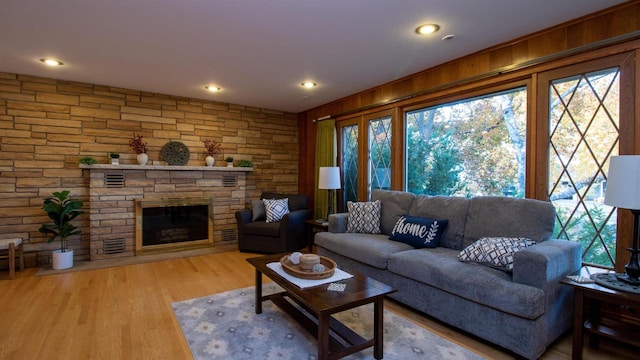 living room with wooden walls, a fireplace, and hardwood / wood-style floors