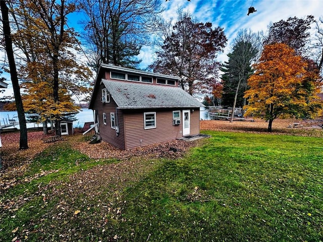 view of side of home with a yard and a water view