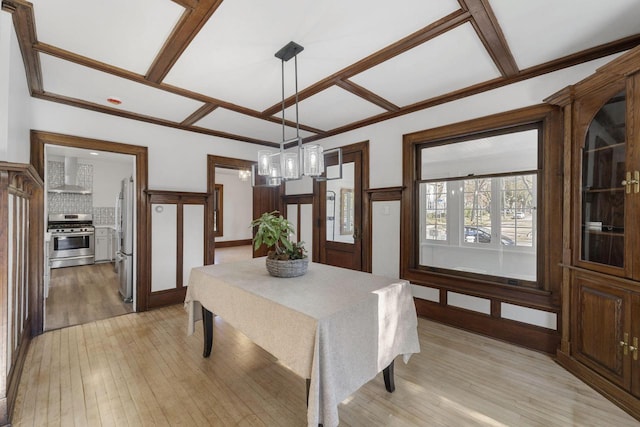 dining area with light hardwood / wood-style flooring and a notable chandelier