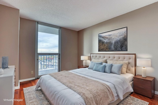 bedroom featuring hardwood / wood-style floors, a textured ceiling, and access to exterior