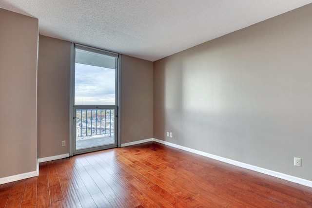 empty room with a textured ceiling and hardwood / wood-style floors