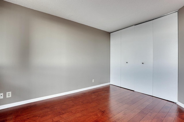 unfurnished bedroom with a textured ceiling and hardwood / wood-style flooring