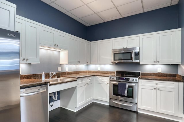 kitchen with white cabinetry, a paneled ceiling, stainless steel appliances, and dark hardwood / wood-style floors