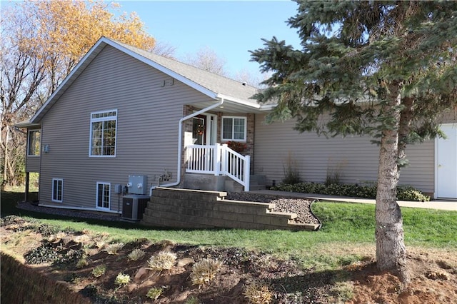 view of front of house with central air condition unit and a front lawn