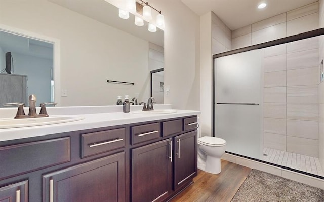 bathroom with vanity, wood-type flooring, toilet, and an enclosed shower