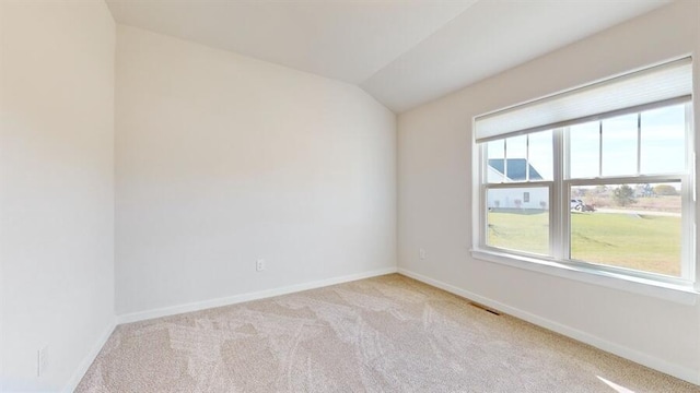 empty room with light carpet and lofted ceiling