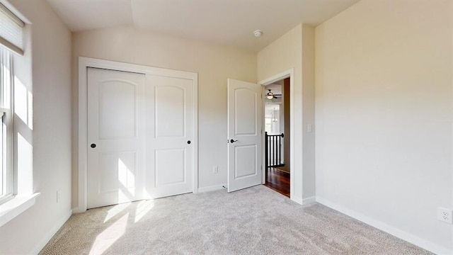 unfurnished bedroom featuring a closet and light carpet