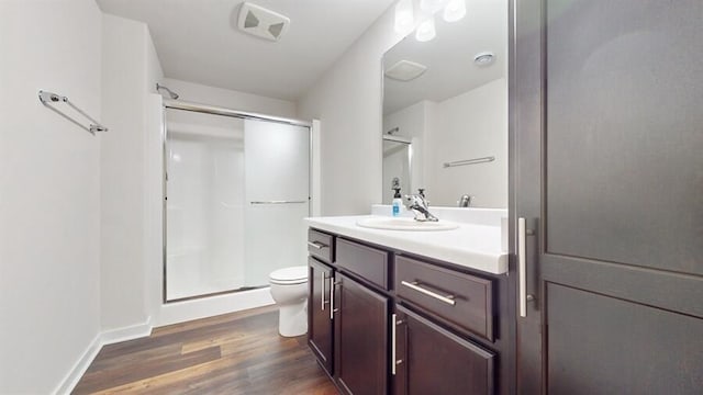 bathroom featuring toilet, vanity, a shower with shower door, and wood-type flooring