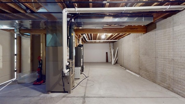 basement featuring brick wall, water heater, and heating unit