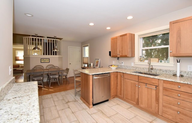 kitchen with stainless steel dishwasher, sink, kitchen peninsula, and a wealth of natural light