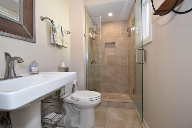 bathroom featuring a shower with door, toilet, and tile patterned flooring