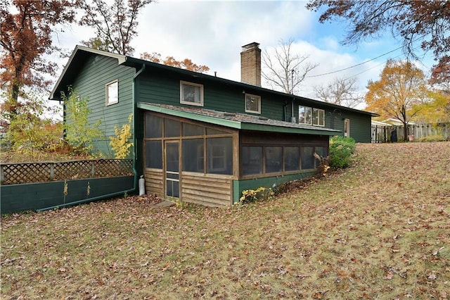 back of house with a yard and a sunroom