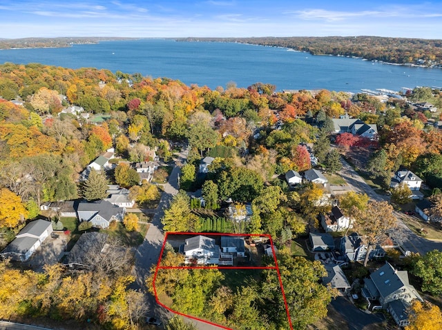 birds eye view of property with a water view, a view of trees, and a residential view