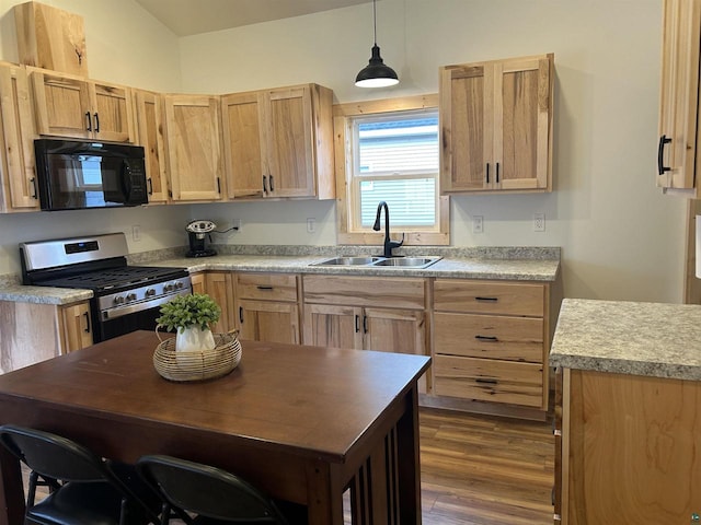 kitchen featuring sink, gas stove, decorative light fixtures, light brown cabinets, and dark hardwood / wood-style floors