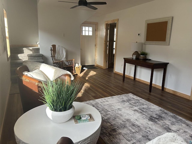 living room featuring dark wood-type flooring and ceiling fan