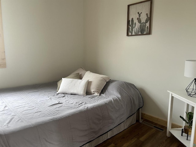 bedroom with dark hardwood / wood-style flooring