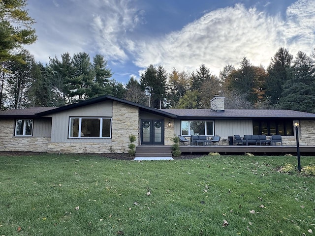 ranch-style home with a deck and a front lawn