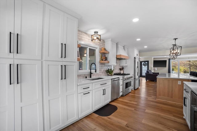 kitchen featuring stainless steel appliances, sink, light wood-type flooring, and white cabinets