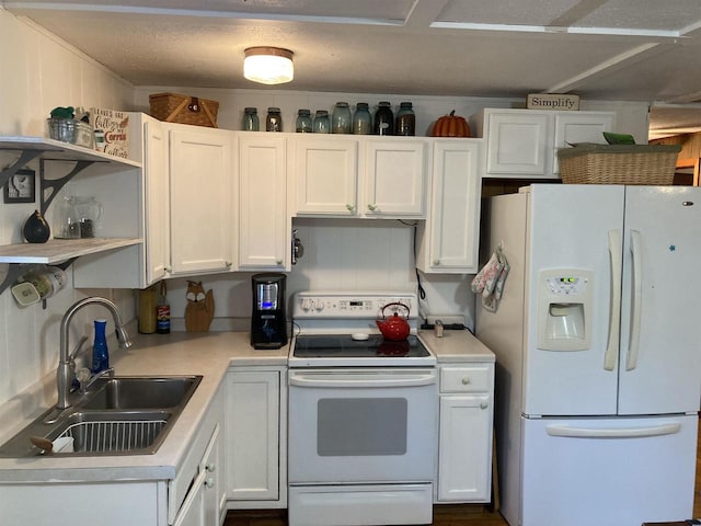 kitchen with white cabinets, sink, and white appliances