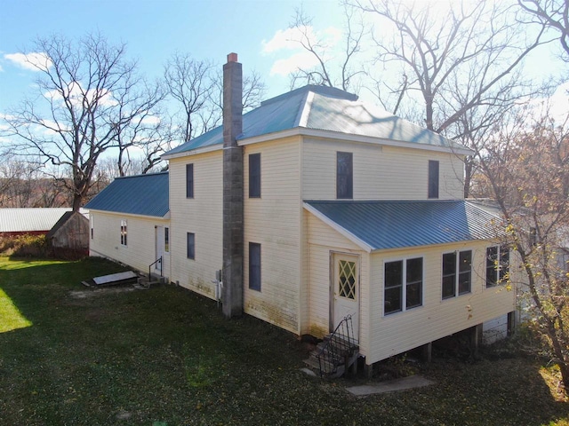 rear view of house featuring a lawn