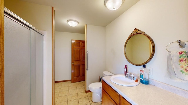 bathroom with vanity, toilet, tile patterned floors, and a shower with door